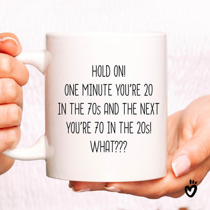 Funny 70th birthday Coffee Mug. it says "Hold on! one minute you’re 20 in the 70s and the next you’re 70 in the 20s! What??? ". 11 oz all white tea cup.