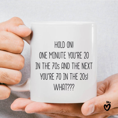 Funny 70th birthday Coffee Mug. it says "Hold on! one minute you’re 20 in the 70s and the next you’re 70 in the 20s! What??? ". 11 oz all white tea cup.